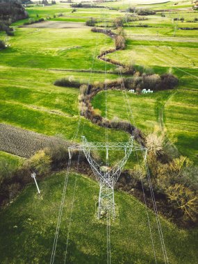Electrical power substation in the country side of Slovenia. Fields and forests surrounding the power station in the suburbs. Aerial view. 