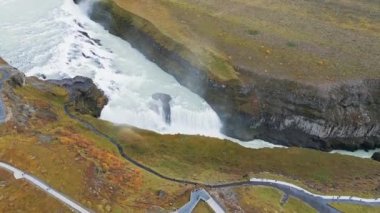 Büyük, güzel bir şelale Gullfoss, İzlanda 'nın ünlü simgesi. Şelaleden düşerken nehirde köpükler uçuşuyor, turistler volta atıyor, şelaleye bir bakış açısıyla bakıyor. Yüksek kaliteli video