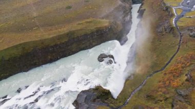 Huge beautiful waterfall Gullfoss, famous landmark in Iceland. River foaming whilst falling down the waterfall, tourist waling by, looking at the waterfall from a view point. High quality video