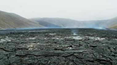 Geldingadalir aktif volkan, 2021 'de Fagradalsfall ve 2022 Meradalir' de patladı. Hala sıcak lav kayaları, yerden gelen buharlar. İzlanda 'da koyu gri, siyah volkanik kayalar. Dramatik görünüm