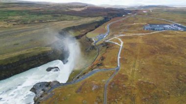 Huge beautiful waterfall Gullfoss, famous landmark in Iceland. River foaming whilst falling down the waterfall, tourist waling by, looking at the waterfall from a view point. High quality video