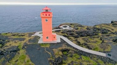 Batı İzlanda 'daki deniz kıyısındaki turuncu Svortuloft Deniz Feneri manzarası, Snaefellsnes yarımadası, Svortuloft Deniz feneri yakınlarındaki Manzara. Muhteşem siyah volkanik kayalık okyanus kıyıları ve mağara kemeri.