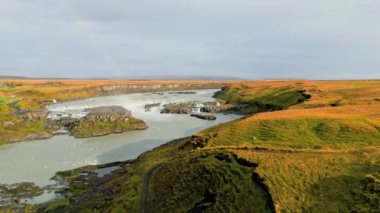 Bright blue river trough Iceland mainland in autumn time on a cold day. High quality video