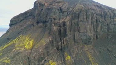 İzlanda anakarasının bir yerlerinde volkanik topraklar var. Etrafı canlı yeşil çalılar ve volkanik arazilerle çevrili. Volkanik kaya oluşumları, küçük dağlar, siyah gri volkanik kayalar. Kimse yok.. 