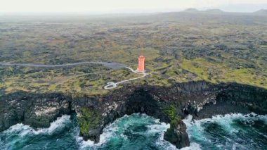 Batı İzlanda 'daki deniz kıyısındaki turuncu Svortuloft Deniz Feneri manzarası, Snaefellsnes yarımadası, Svortuloft Deniz feneri yakınlarındaki Manzara. Muhteşem siyah volkanik kayalık okyanus kıyıları ve mağara kemeri.