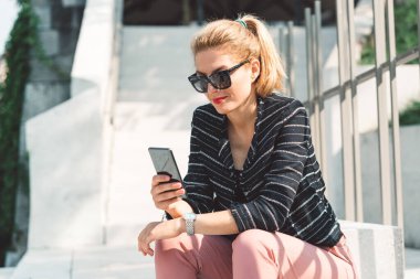 Beautiful caucasian woman living in the city. Woman spending her day in the city, sun is shining, weather is nice. Young millennial person living in the city, doing his daily errands. 