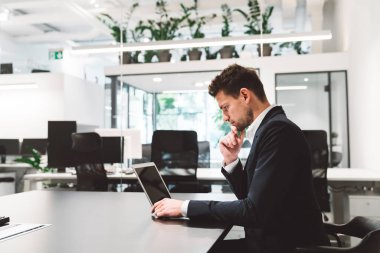 Office full of caucasian business people of different ages working at their desks. Caucasian business man and women working in a new modern bright offices with glass walls. People on business meetings