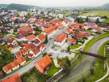 Drone stills of a small town in the countryside in autumn. River running trough the town, aerial view. 
