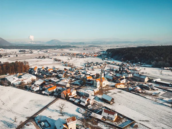 Aerial view of small winter town, snow on the grounds, sunny winter day.