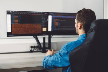 Bilgisayarda çalışan bilişim programcısı. Erkek Uzman Yaratıcı Yenilikçi Yazılım Mühendisliği Geliştirme Uygulaması, Program, Video Oyunu. Kodlama Dili Terminali. Omzunun üstünden. Yüksek kalite fotoğraf