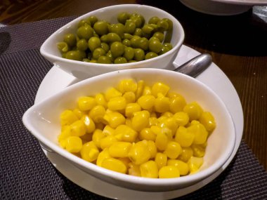Salamura edilmiş yeşil fasulye ve mısır taneleri ana yemeğe eşlik eder..