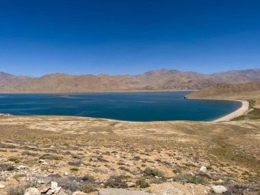 Kıyı bir dağ gölü geçidi gibi..