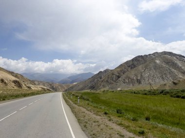 Kırgızistan 'daki dağlardan geçen bir yol..