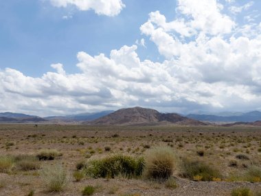 Yağmurdan önce dağlarla dolu bir çayır.