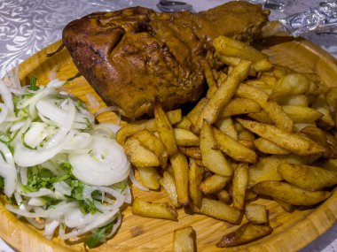 Kızarmış kuzu budu, patates ve soğanlı..