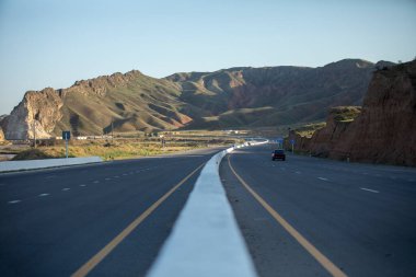 Kırmızı bir araba yüksek yolda.