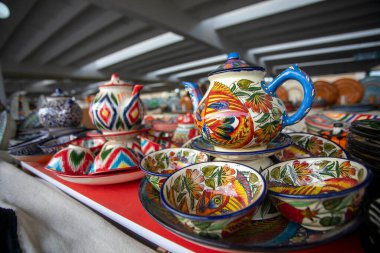 Renkli desenli seramik çay seti ve balık tasviri..