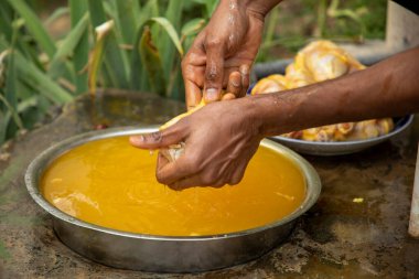 Tavuğu Hint metoduyla yıkayan bir çocuk.