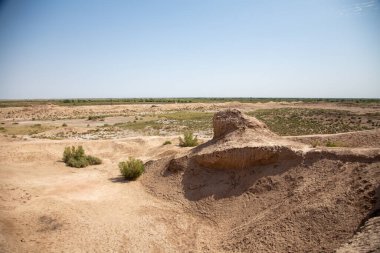 Büyük kayalar ve çamurlu bir çöl bölgesi.