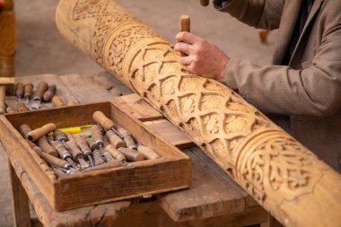 Elleriyle ahşap kiriş yapan bir adam. Eski geleneksel yöntemlerle, eski el sanatları, Khiva, Horesm tarımsal vahası, Hisar..