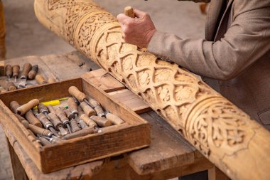 Elleriyle ahşap kiriş yapan bir adam. Eski geleneksel yöntemlerle, eski el sanatları, Khiva, Horesm tarımsal vahası, Hisar..