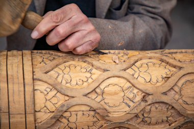 Elleriyle ahşap kiriş yapan bir adam. Eski geleneksel yöntemlerle, eski el sanatları, Khiva, Horesm tarımsal vahası, Hisar..