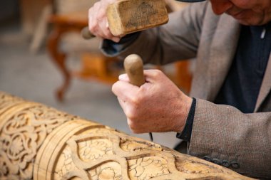 Elleriyle ahşap kiriş yapan bir adam. Eski geleneksel yöntemlerle, eski el sanatları, Khiva, Horesm tarımsal vahası, Hisar..