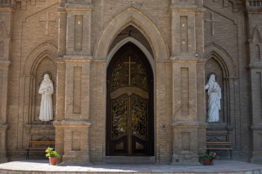 Kilisenin girişinde heykelin yanında iki papaz vardı.