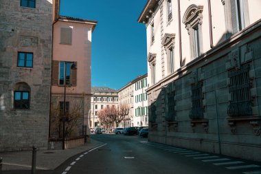 Caddenin sağ tarafında bir bina olan bir cadde. Sokaklar boş ve gökyüzü mavi.