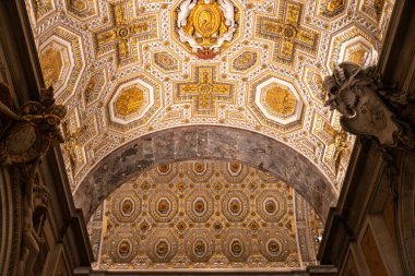 Bir binanın tavanı altın ve beyaz tasarımlarla süslenmiştir. Altın çok göze çarpıyor ve beyaz daha ince. Tasarım çok karmaşık ve detaylı.