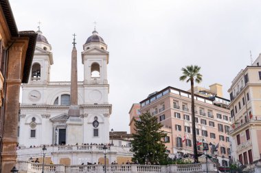 Uzun kolonu ve iki kubbesi olan büyük beyaz bir bina. Bina kalabalık bir kalabalıkla çevrili.