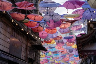 Tavandan sarkan renkli şemsiyeler tuhaf ve eğlenceli bir atmosfer yaratıyor.