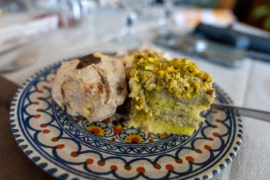 Üzerinde bir dilim kek ve dondurma olan bir tabak tatlı. Tatlı beyaz kenarlı mavi bir tabakta servis edilir.