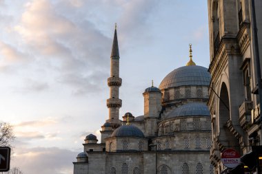Üzerinde kırmızı işaret olan büyük bir bina. Gökyüzü bulutlu.