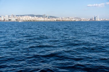 Okyanus sakin ve gökyüzü açık. Su mavi ve ufuk görünür.