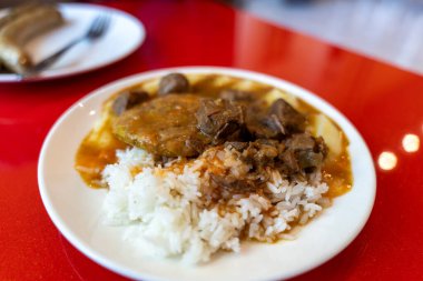 Üzerinde pirinç ve et olan bir tabak yemek.