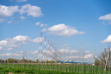 Birkaç bulutlu mavi bir gökyüzü ve arka planda bir tren