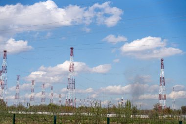 Bir sürü uzun elektrik hattı ve gökyüzünde birkaç bulut olan bir alan.