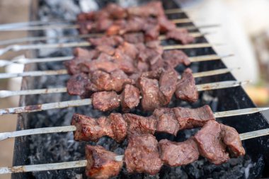 Izgarada bir et şişi pişiyor. Et kahverengi ve o iyi pişmiş.