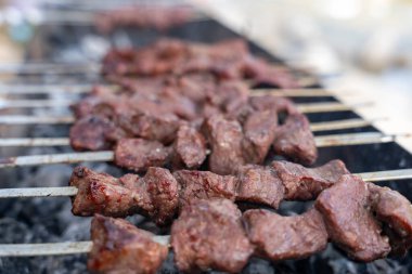 Izgarada bir et şişi pişiyor. Et kahverengi ve o iyi pişmiş.