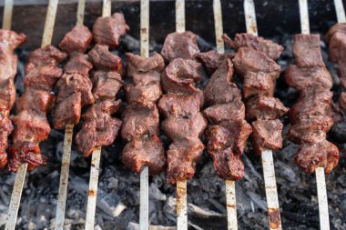 Izgarada bir et şişi pişiyor. Et kahverengi ve o iyi pişmiş.