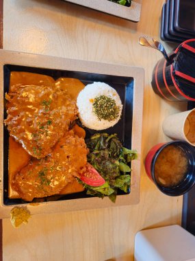 Sebzeli ve pirinçli bir tabak yemek masada oturur.