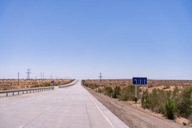 Üzerinde 111 yazan mavi işaretli bir yol. Yol boş ve üzerinde hiç araba yok.