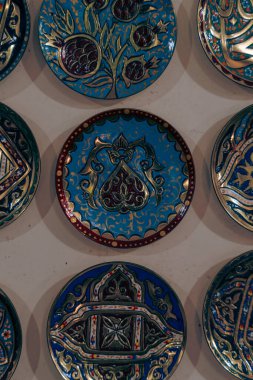 Üzerinde tasarım olan mavi ve kırmızı tabaklar koleksiyonu. Tabaklar bir sıraya dizildi.