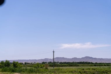 Ortasında elektrik direği olan açık mavi bir gökyüzü. Gökyüzü bomboş ve sahnedeki tek şey direk.