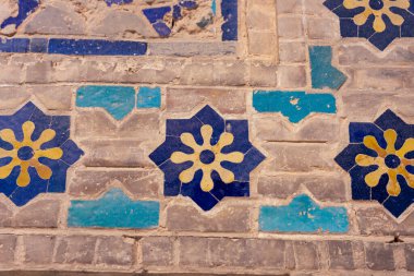 Mavi ve sarı çiçekli bir mozaik zemin. Mavi ve sarı renkler canlı ve canlı bir atmosfer yaratır. Çiçekler öyle bir düzenlenmiş ki sanki çiçek açıyorlar.