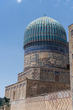 Arapça yazılı bir binanın üzerinde mavi bir kubbe. Bina yüksek ve üzerinde çok fazla detay var.