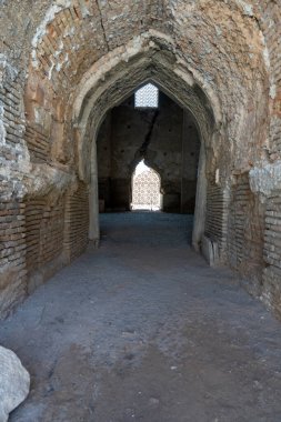 Dar, kemerli bir kapı, taştan zemini olan bir odaya açılıyor.