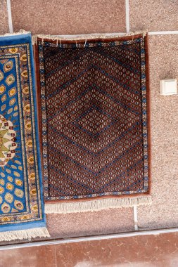 Duvarda mavi ve kahverengi bir halı var.