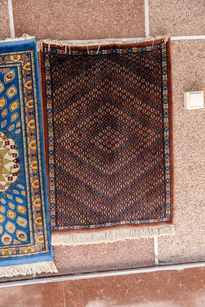 Duvarda mavi ve kahverengi bir halı var.